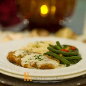 Fried chicken with sauce and green beans on a plate inside of Alegria Gardens Reception Hall in Houston.