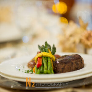 Steak with asparagus and bell peppers on a table in the dining hall at Alegria Gardens Reception Hall in Houston.