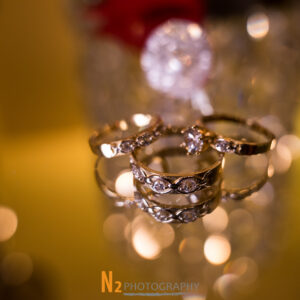 A picture of three intricate rings taken on a glass surface at Alegria Gardens Reception Hall in Houston.