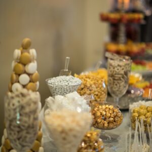 Dessert table featuring candy, cake pops, macarons, and coated pretzels at Alegria Gardens Reception Hall in Houston.