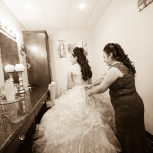 A picture of a bride getting into her dress before a wedding at Alegria Gardens Reception Hall in Houston.