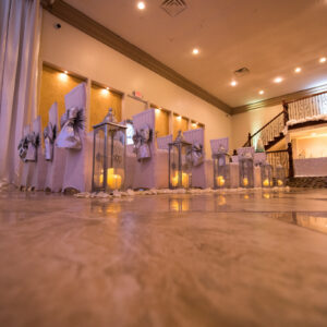 A picture of decorated chairs taken from the floor of the dining hall at Alegria Gardens Reception Hall in Houston.