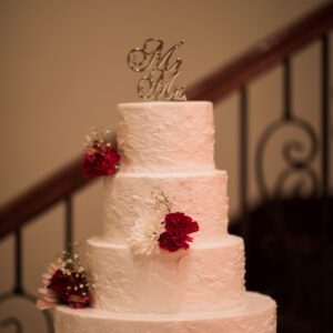 White cake with red roses at our wedding venue - Alegria Gardens