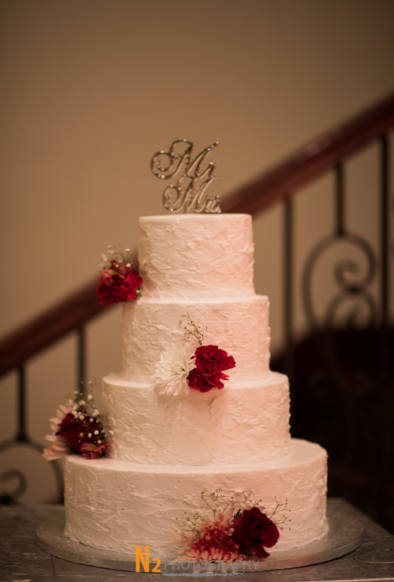 White cake with red roses at our wedding venue - Alegria Gardens