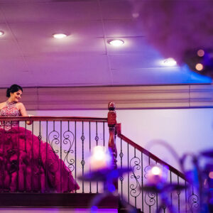Girl in quinceanera dress on stairs at our party hall - Alegria Gardens