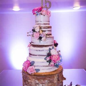 Layered wedding cake with pink flowers at our reception hall - Alegria Gardens