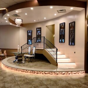 A picture of a table, two chairs, and a staircase at Alegria Gardens Reception Hall at Stacy in Houston.