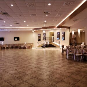A photograph of the spacious dining area with tables and chairs in the background at Alegria Gardens Reception Hall at Stacy in Houston.